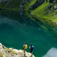 Escursionisti ammirano un lago alpino turchese vicino al bivacco Paolo e Nicola.