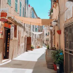 Un vicolo pittoresco con panni stesi, vasi di fiori e una pizzeria. Un luogo incantevole dove passeggiare e scoprire cosa vedere.