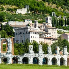 Rovine antiche e borgo medievale a Gubbio, Umbria, con vista sulle colline verdi. Un viaggio da Perugia a Gubbio tra storia e natura.