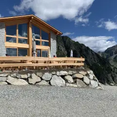 Il rifugio Cornisello, con la sua architettura in legno e pietra, si staglia maestoso tra le vette. Un luogo ideale per una pausa panoramica.