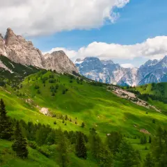 Verdi pendii montani con cime rocciose e innevate, perfetti per un'idea di **3 giorni in montagna dove andare**.