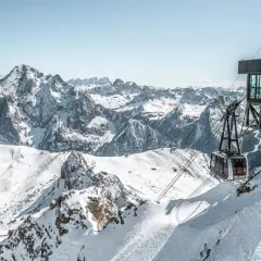 Panoramica mozzafiato dal belvedere di Canazei: una funivia scende tra le cime innevate delle Dolomiti.