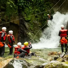 Avventura di canyoning in Trentino: un gruppo si prepara a scendere una cascata, immersi nella natura selvaggia.