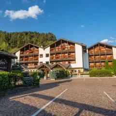 Residence Lagorai, un'accogliente struttura con balconi fioriti, immersa nel verde alpino.