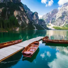 Barche di legno ormeggiate su un pontile in un lago alpino, circondato da montagne imponenti e foreste verdi. Un paesaggio da sogno tra i laghi trentino.