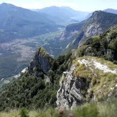 Vista mozzafiato dal Monte Casale, con valli verdi, un lago azzurro e montagne imponenti all'orizzonte.