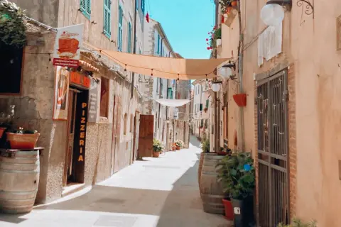 Un vicolo pittoresco con panni stesi, vasi di fiori e una pizzeria. Un luogo incantevole dove passeggiare e scoprire cosa vedere.