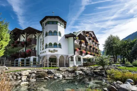 Kristiania Pure Nature Hotel & Spa, un'oasi di pace con un ruscello e fiori colorati.