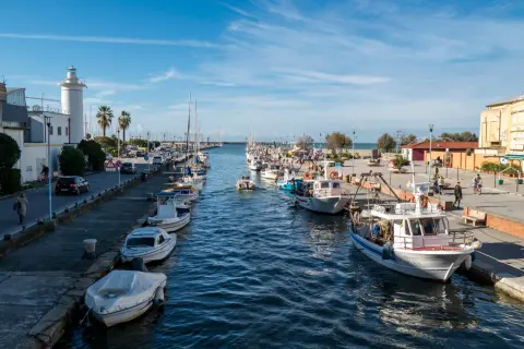 Porto di Viareggio con barche ormeggiate e un faro bianco. Ideale per scoprire cosa fare a Viareggio, tra passeggiate sul molo e gite in barca.