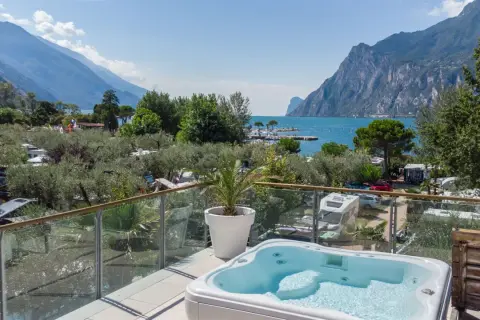Vista da un idromassaggio su un camping Maroadi con lago e montagne.