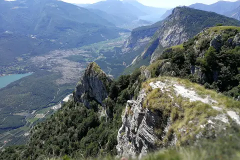Vista mozzafiato dal Monte Casale, con valli verdi, un lago azzurro e montagne imponenti all'orizzonte.