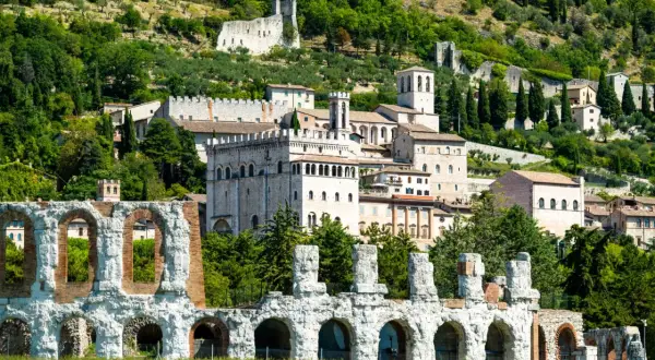 Rovine antiche e borgo medievale a Gubbio, Umbria, con vista sulle colline verdi. Un viaggio da Perugia a Gubbio tra storia e natura.