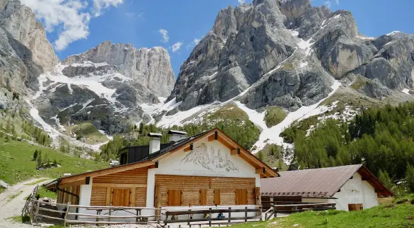 Malga Contrin, un rifugio alpino in legno e pietra, si erge ai piedi di maestose vette dolomitiche innevate.