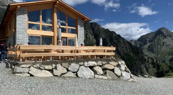 Il rifugio Cornisello, con la sua architettura in legno e pietra, si staglia maestoso tra le vette. Un luogo ideale per una pausa panoramica.
