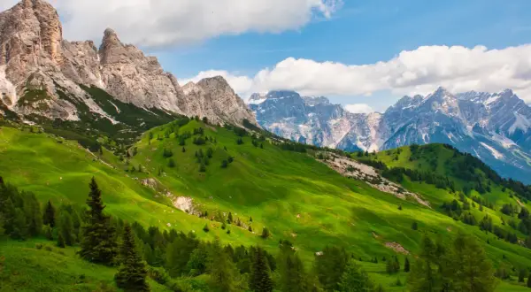 Verdi pendii montani con cime rocciose e innevate, perfetti per un'idea di **3 giorni in montagna dove andare**.
