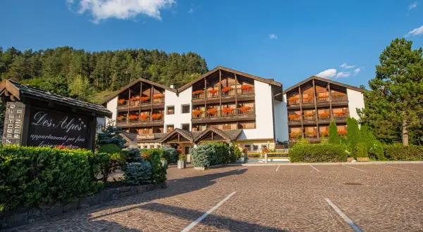 Residence Lagorai, un'accogliente struttura con balconi fioriti, immersa nel verde alpino.