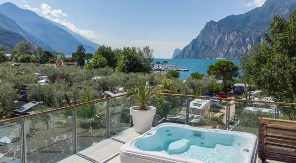 Vista da un idromassaggio su un camping Maroadi con lago e montagne.
