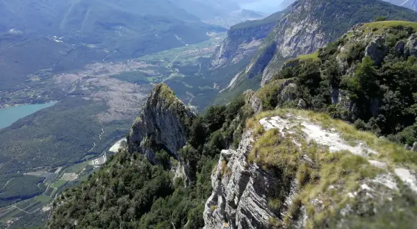 Vista mozzafiato dal Monte Casale, con valli verdi, un lago azzurro e montagne imponenti all'orizzonte.