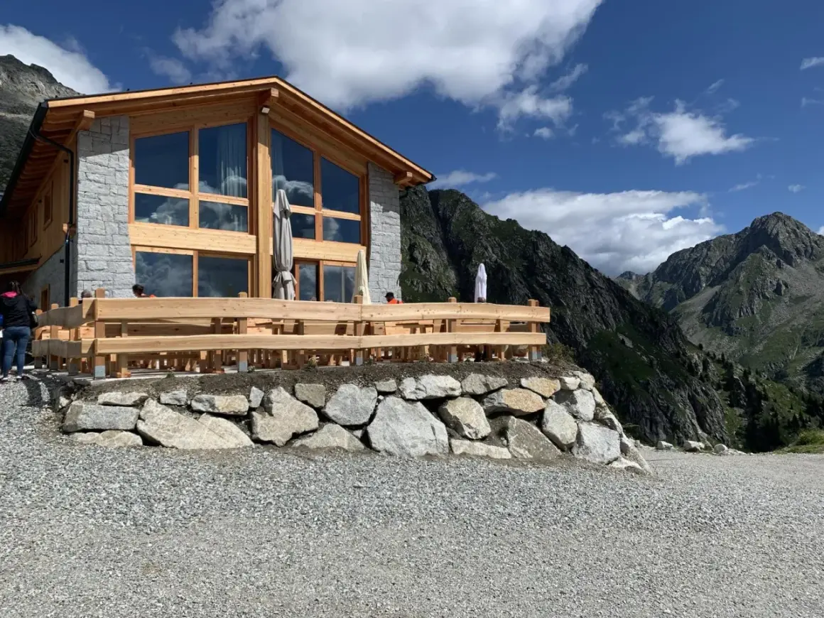 Il rifugio Cornisello, con la sua architettura in legno e pietra, si staglia maestoso tra le vette. Un luogo ideale per una pausa panoramica.