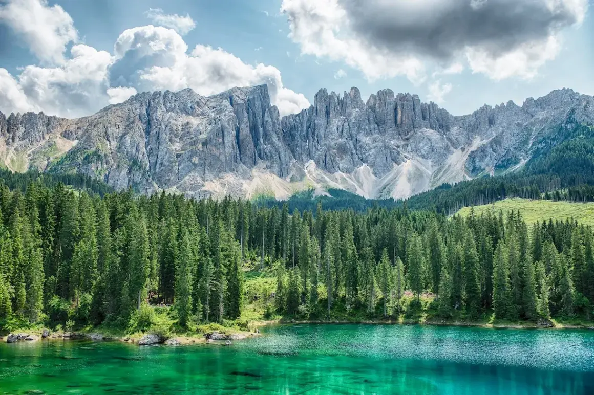 Lago di Carezza, un gioiello del Val di Fiemme cosa vedere. Montagne maestose, boschi di abeti e acque cristalline.