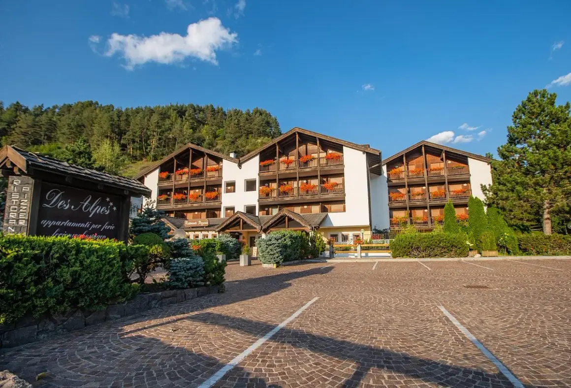 Residence Lagorai, un'accogliente struttura con balconi fioriti, immersa nel verde alpino.
