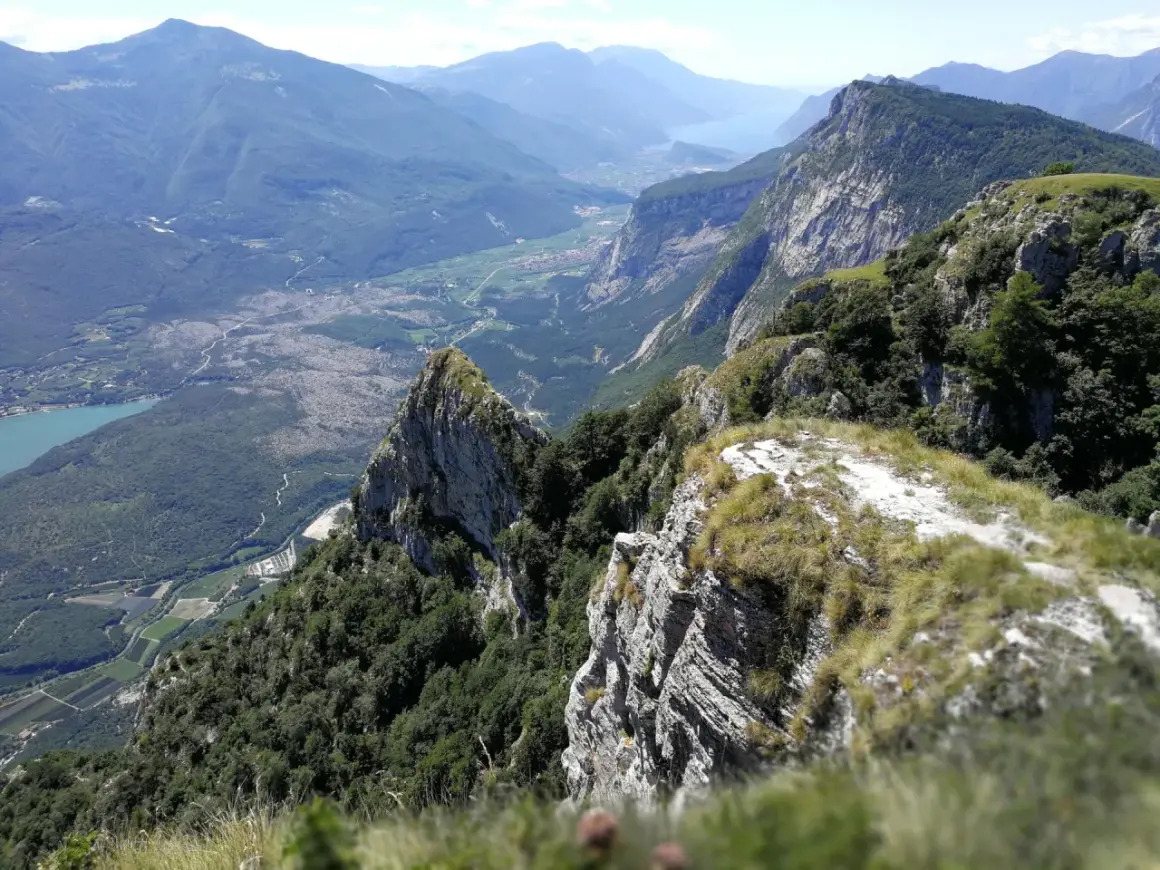 Vista mozzafiato dal Monte Casale, con valli verdi, un lago azzurro e montagne imponenti all'orizzonte.