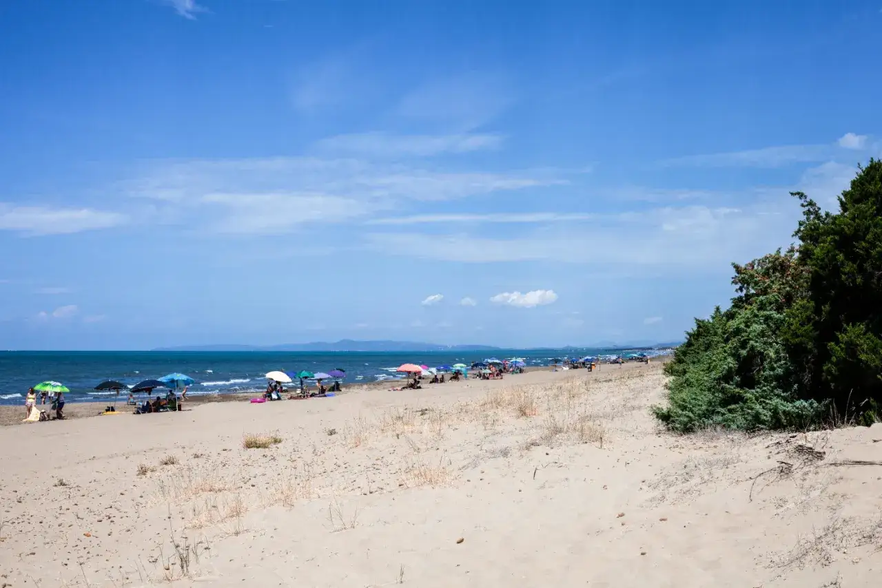 Spiaggia di San Vincenzo con ombrelloni colorati e gente che si gode il sole.