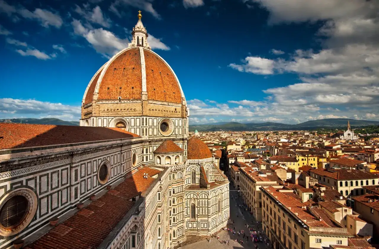 Cupola del Duomo di Firenze, un'icona per scoprire le cose da fare a Firenze. Vista panoramica sulla citt&agrave; con cielo azzurro e nuvole.