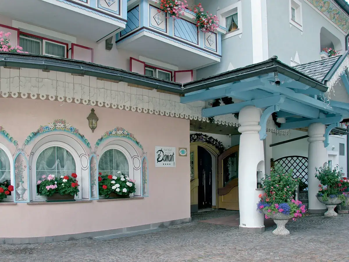 Ingresso decorato con fiori e affreschi al Park Hotel Diamant. L'architettura alpina &egrave; colorata e accogliente.