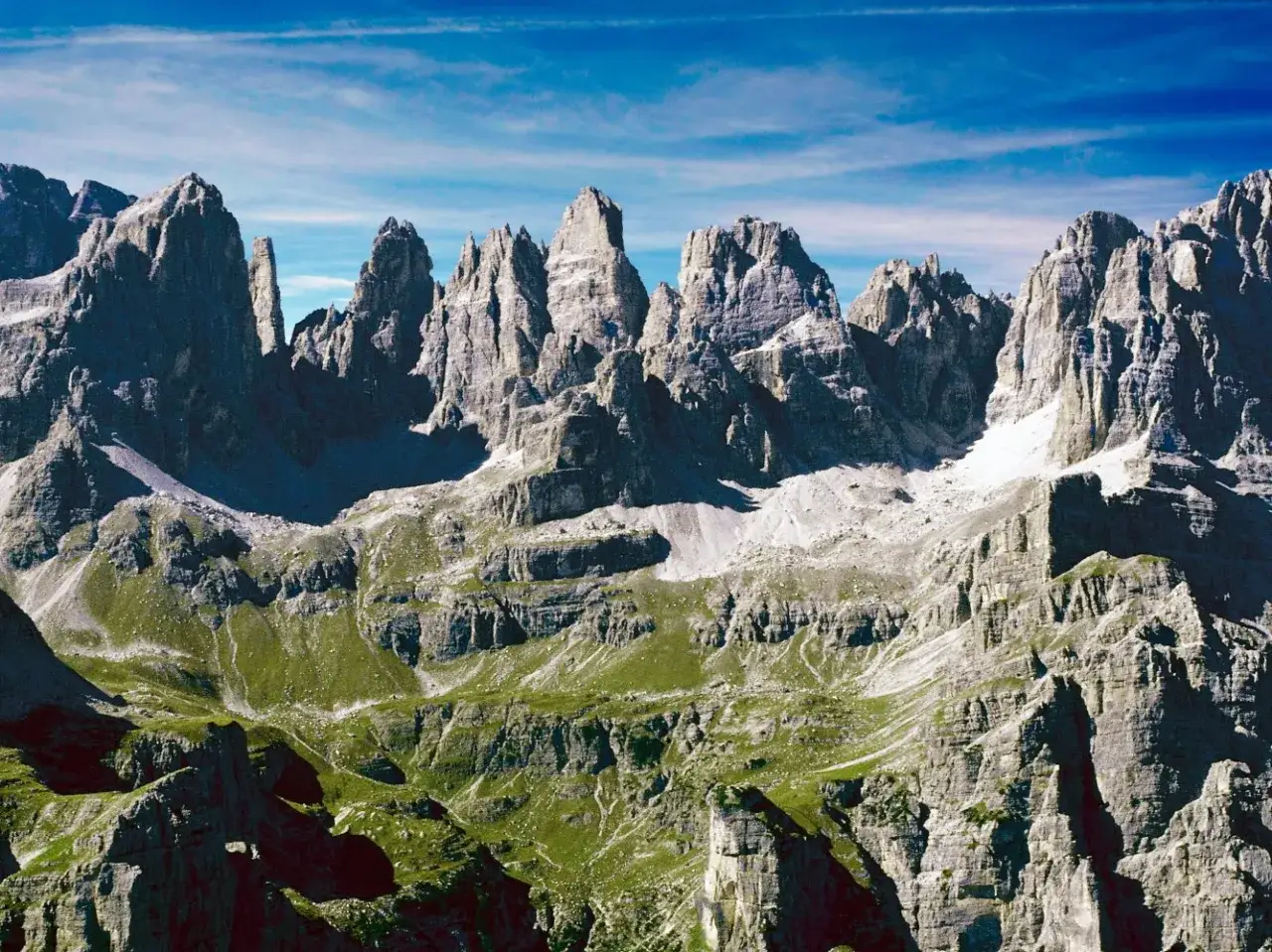 Cime rocciose imponenti e verdi pendii alpini, un paesaggio mozzafiato ideale per le ferrate Trentino.