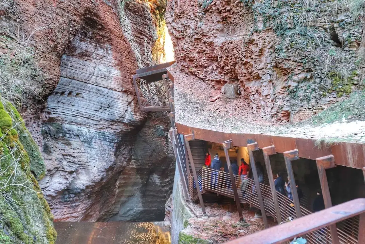 Sentiero attrezzato nell'orrido di Ponte Alto, tra rocce stratificate e strutture metalliche che guidano i visitatori.
