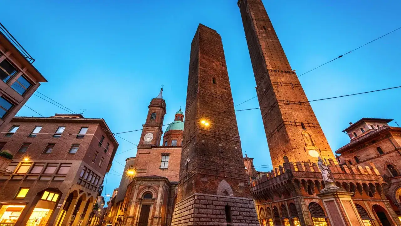 Le Due Torri, simbolo di Bologna, svettano al crepuscolo. Un must per chi cerca cosa vedere a Bologna, tra storia e architettura.
