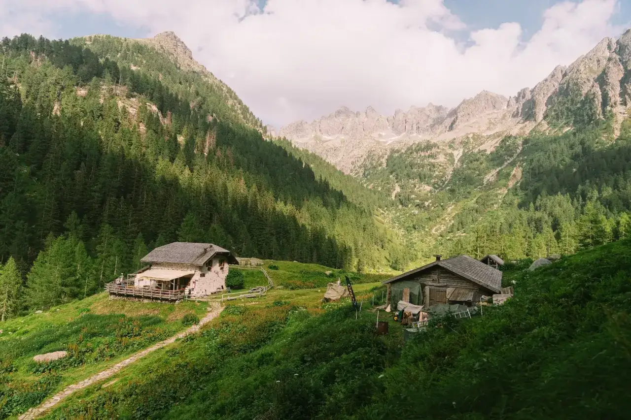 Il rifugio Caldenave, immerso nel verde, accoglie escursionisti tra maestose montagne e fitti boschi.