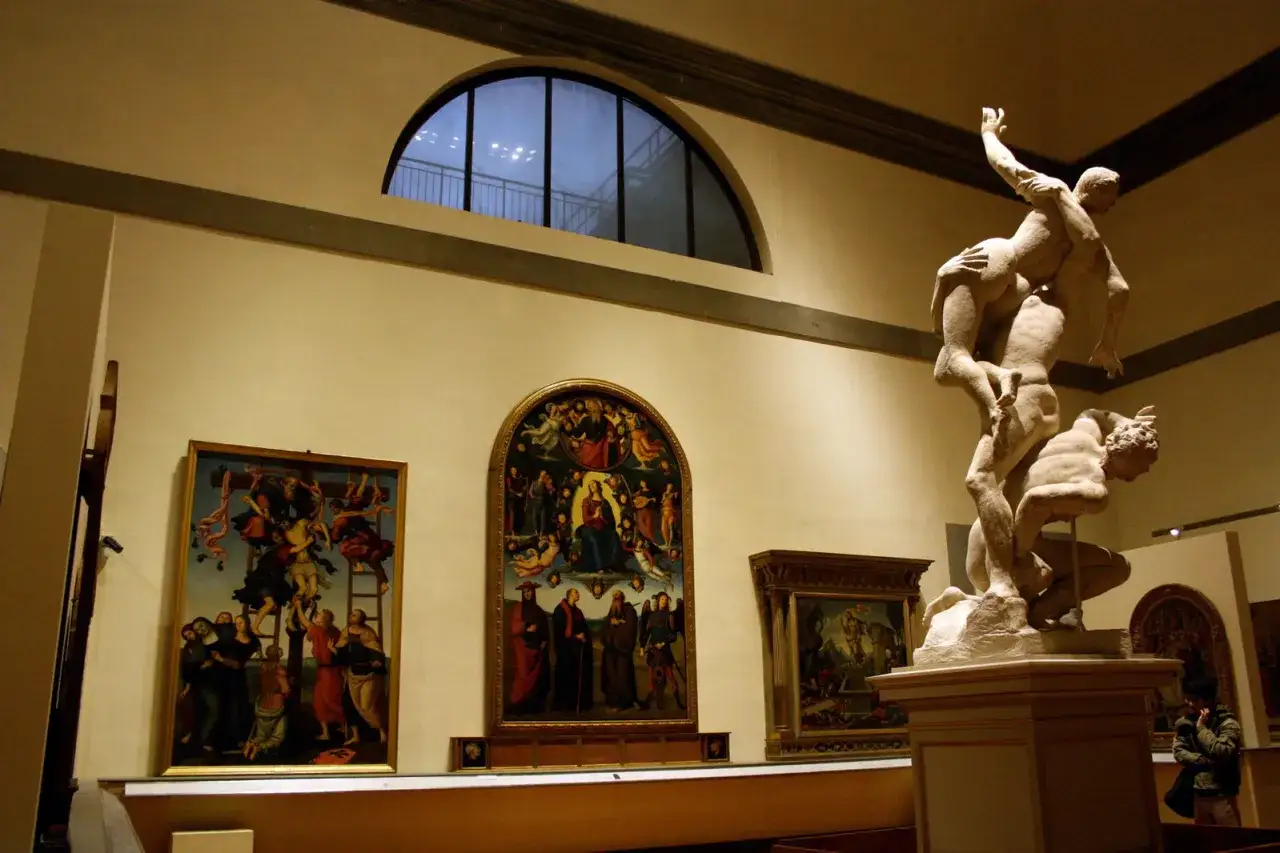 Scultura di Ercole e Caco nella Gallerie dell'Accademia, Firenze, con dipinti alle pareti.