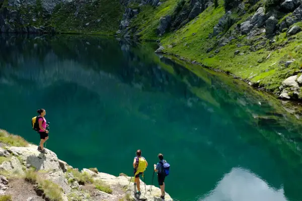 Escursionisti ammirano un lago alpino turchese vicino al bivacco Paolo e Nicola.