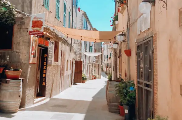 Un vicolo pittoresco con panni stesi, vasi di fiori e una pizzeria. Un luogo incantevole dove passeggiare e scoprire cosa vedere.