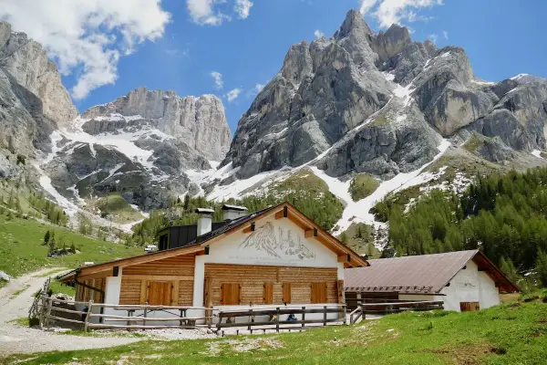 Malga Contrin, un rifugio alpino in legno e pietra, si erge ai piedi di maestose vette dolomitiche innevate.