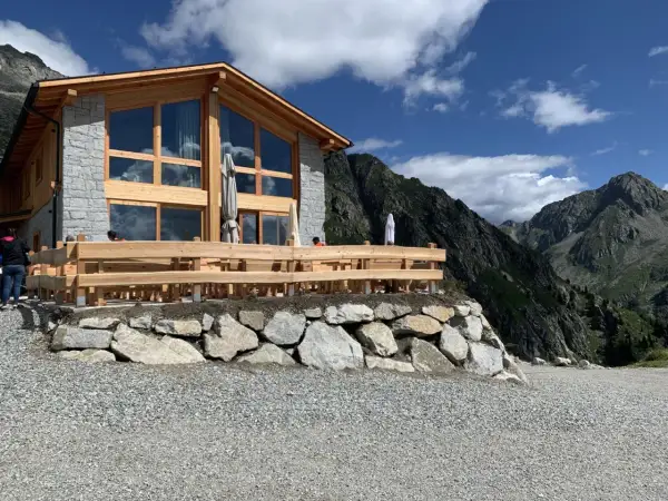 Il rifugio Cornisello, con la sua architettura in legno e pietra, si staglia maestoso tra le vette. Un luogo ideale per una pausa panoramica.