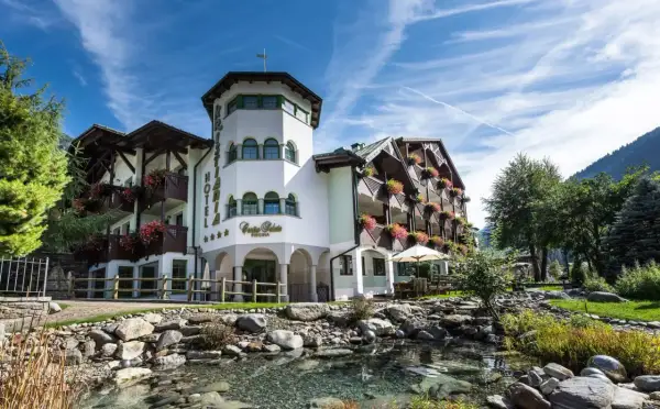 Kristiania Pure Nature Hotel & Spa, un'oasi di pace con un ruscello e fiori colorati.