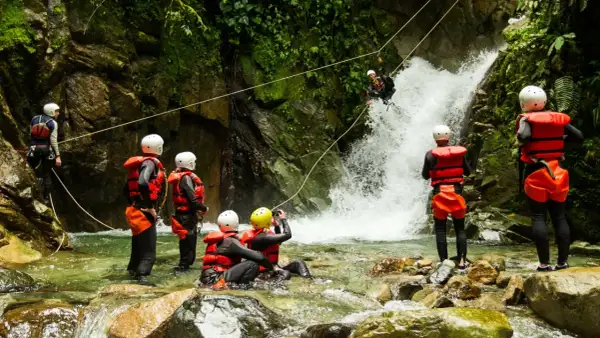 Avventura di canyoning in Trentino: un gruppo si prepara a scendere una cascata, immersi nella natura selvaggia.