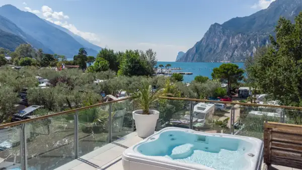 Vista da un idromassaggio su un camping Maroadi con lago e montagne.