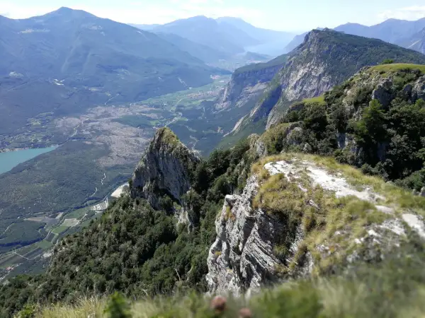 Vista mozzafiato dal Monte Casale, con valli verdi, un lago azzurro e montagne imponenti all'orizzonte.